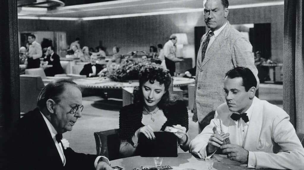 The Colonel and Jean play cards with Charles with suspicious minder Muggsy looking on