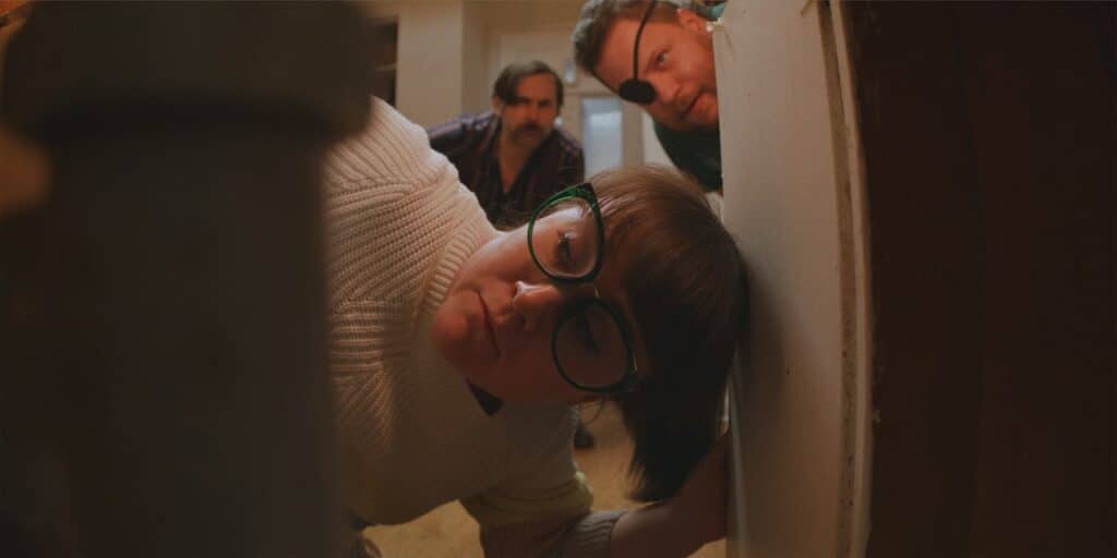 Jane pokes her head into a kitchen cupboard