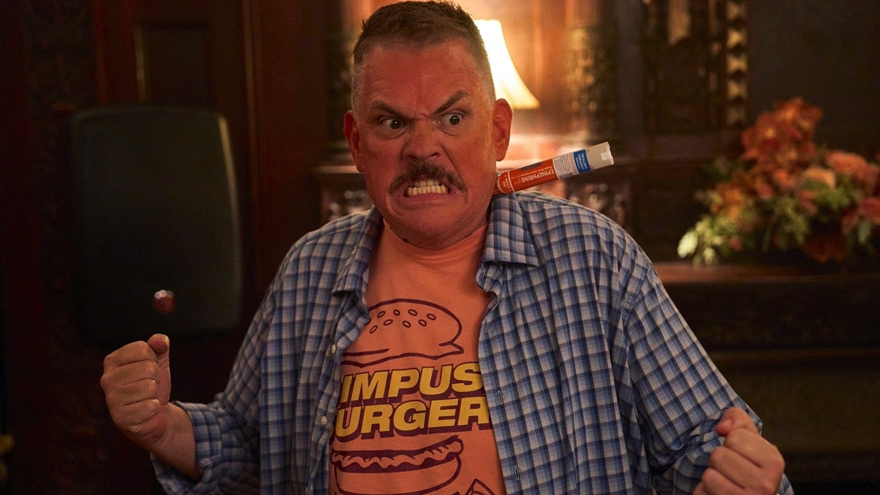 Farva with clenched fist, bared teeth and an epi-pen sticking out of his neck